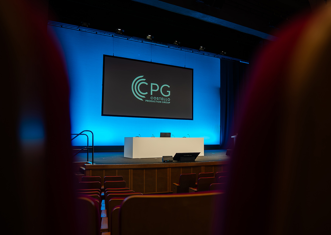 A theatre stage displaying the Costello Production Group logo.