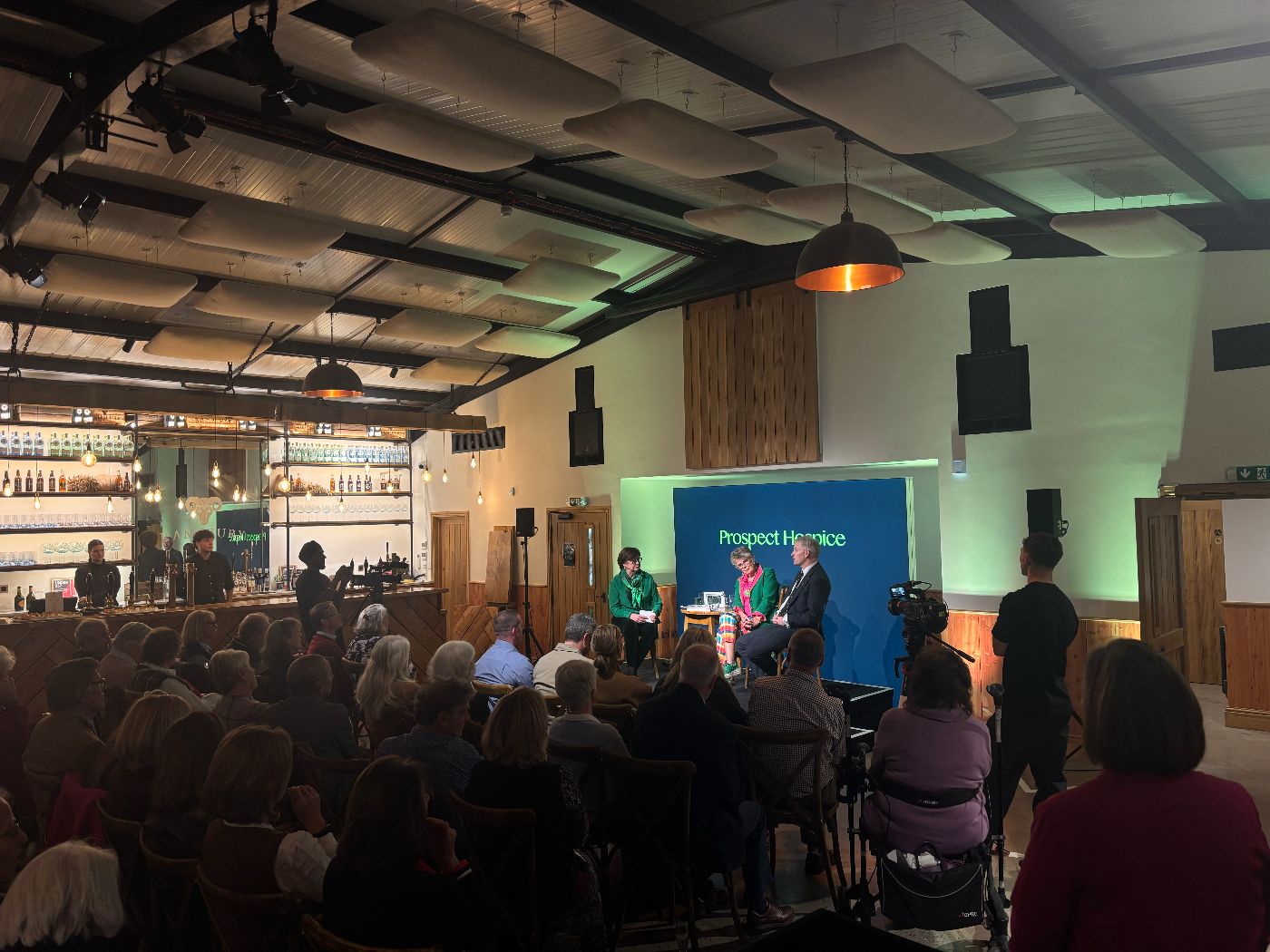 The Prospect Hospice event, showing the presenters on stage and the audience.