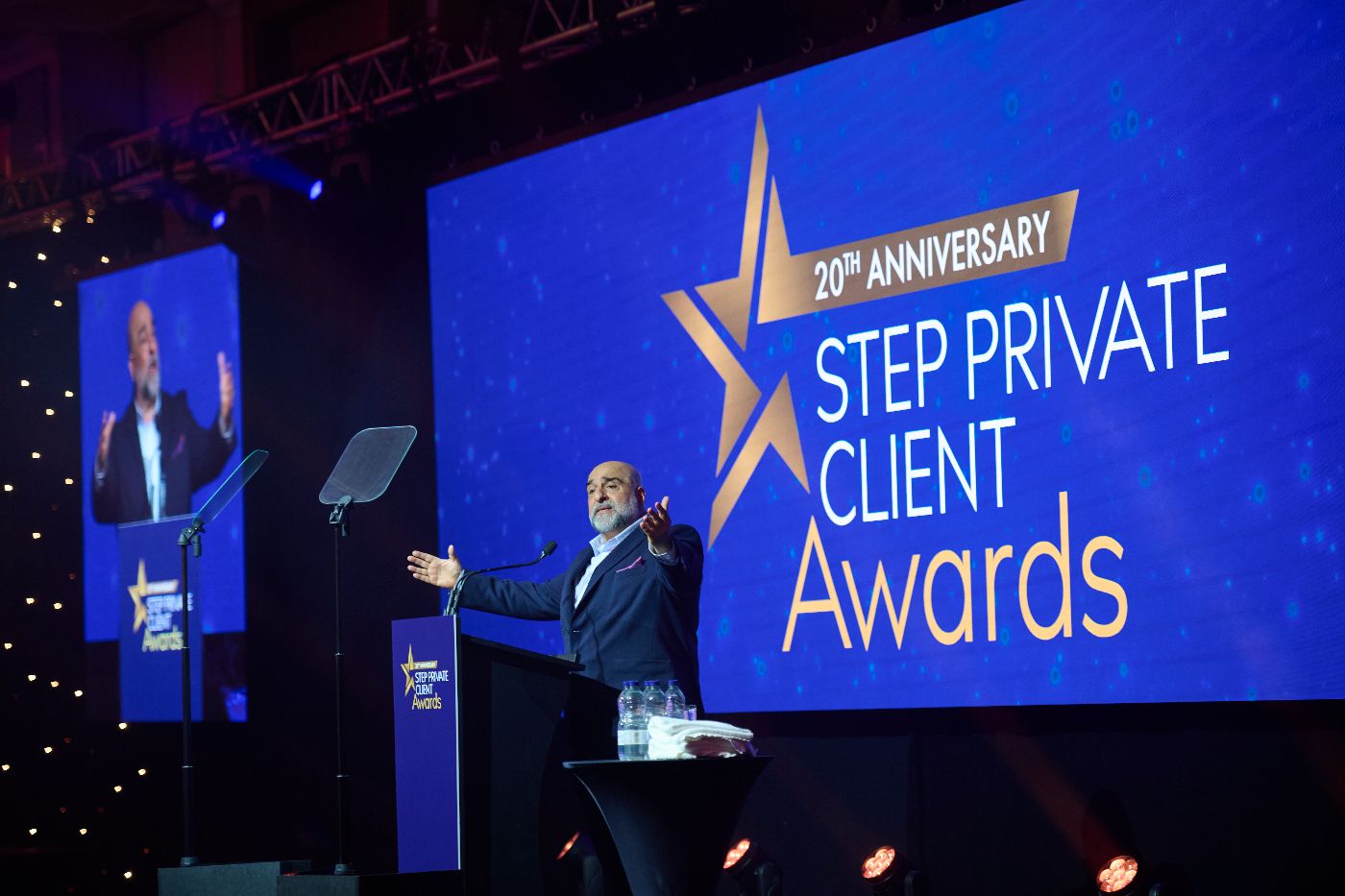 A man stood on stage in front of a screen that says STEP Private Client Awards
