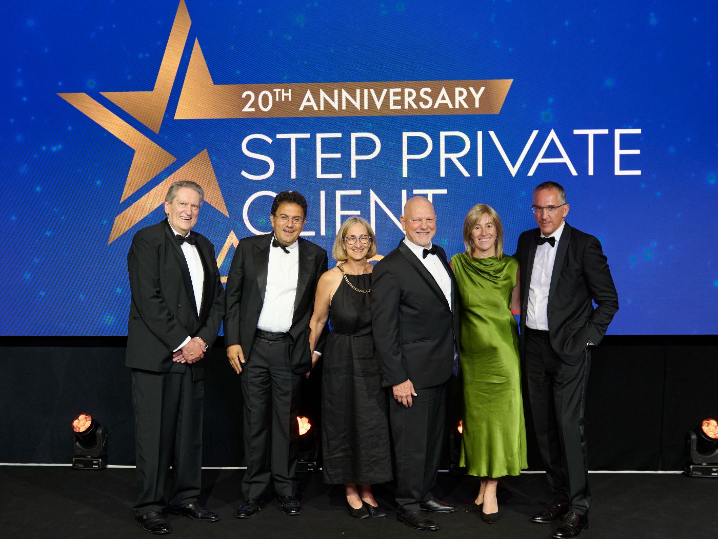 People posing for a photo in front of the STEP Private Client stage