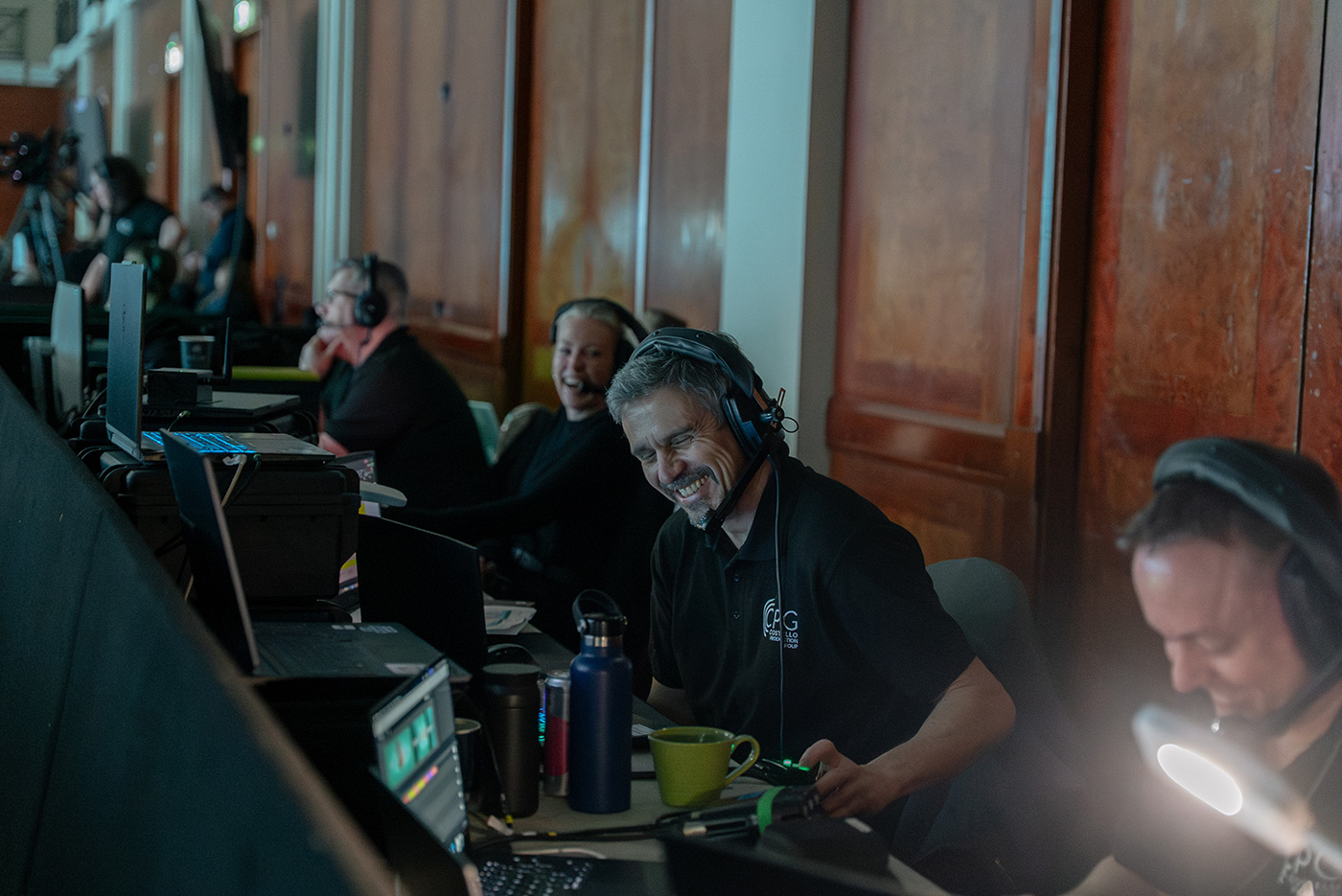Event production team member laughing with the team behind the equipment