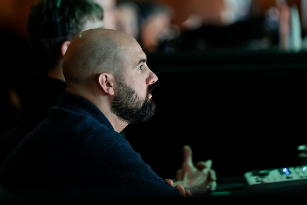An event production manager watching something that's happening off-camera.